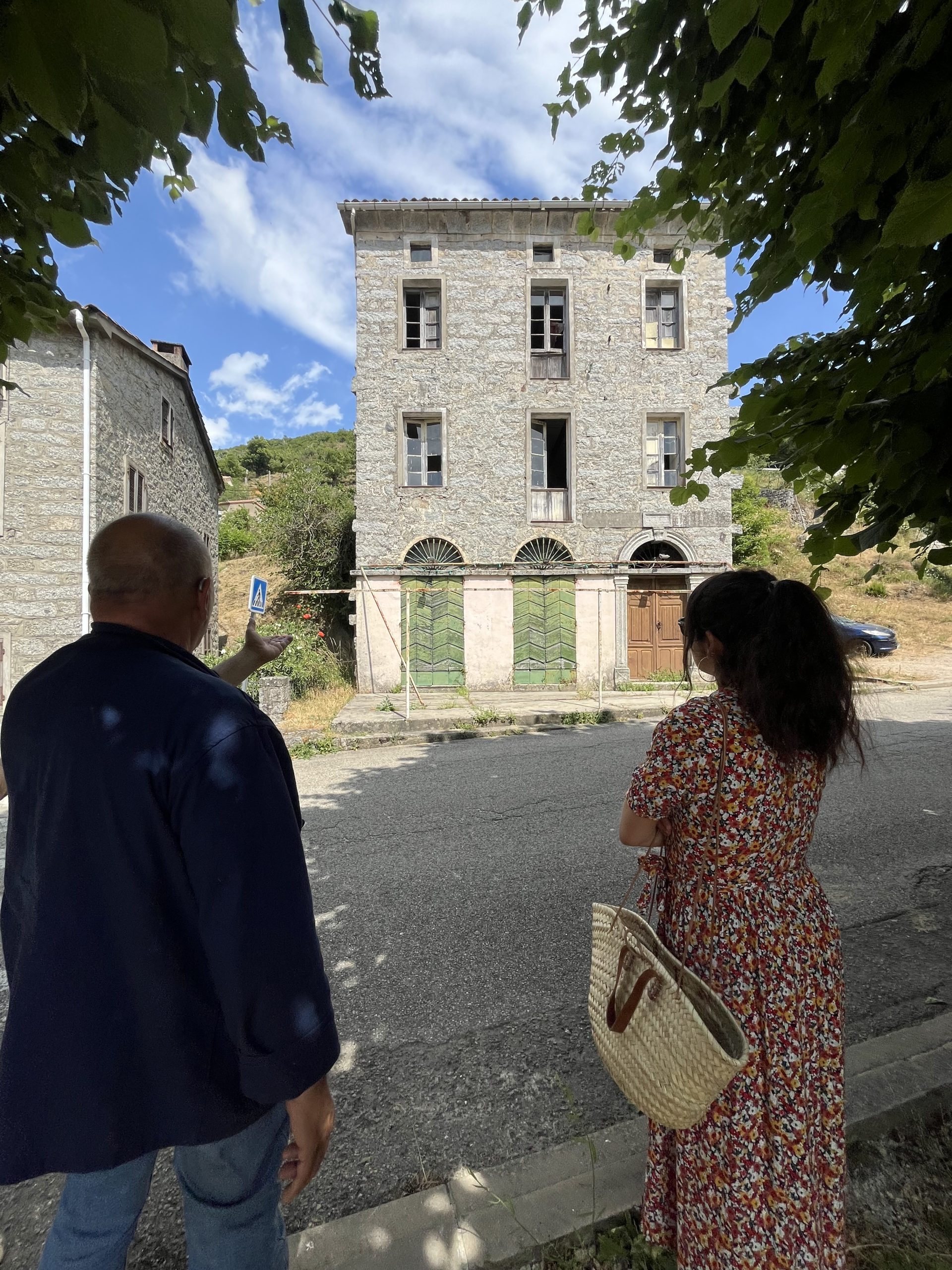 Le maire de Frasseto à gauche montre à une collaboratrice de l'AUE une bâtisse remarquable de son village, faite de pierre et à plusieurs étages. Rôle missions AUE Corse